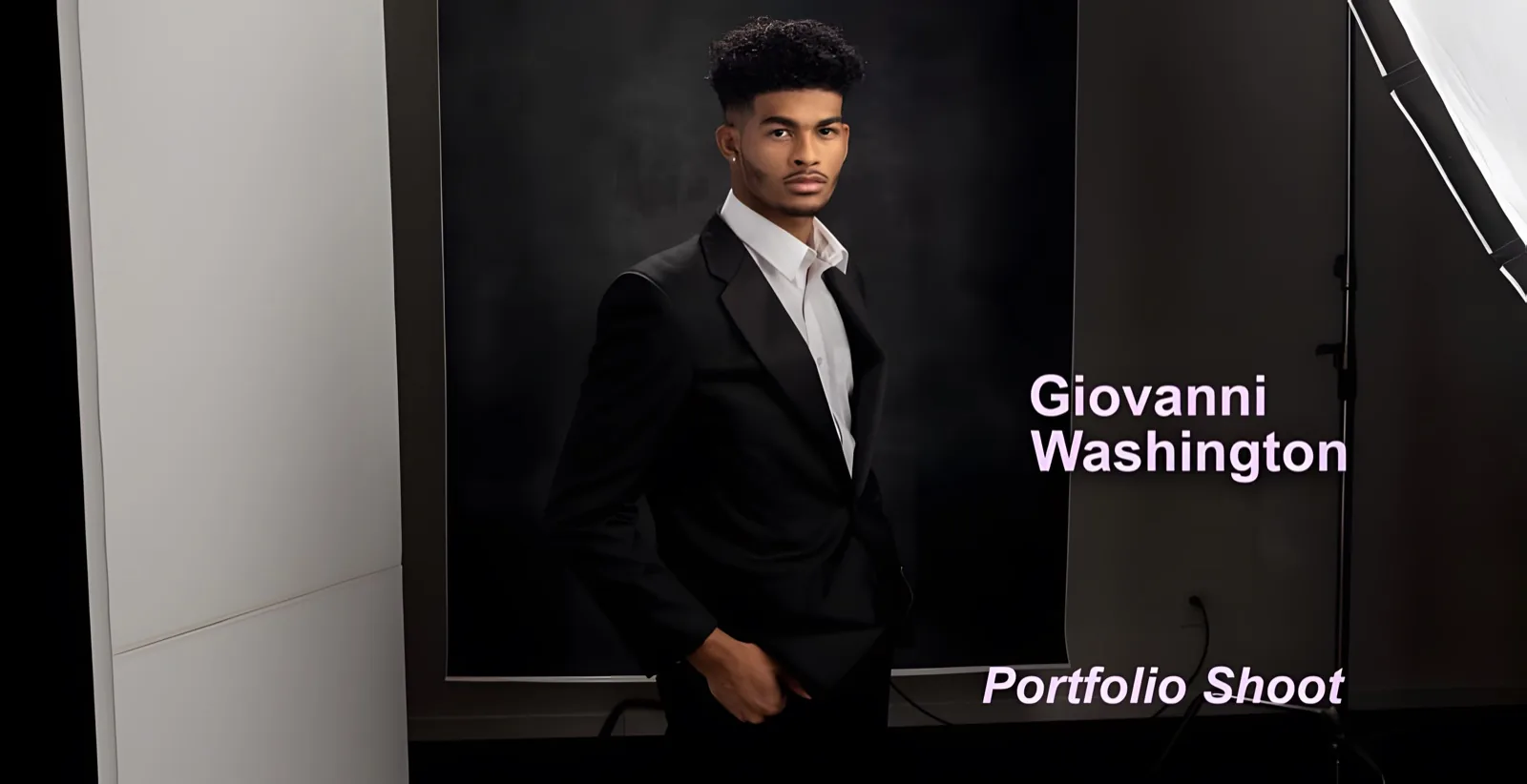 Cover graphic reading Giovanni Washington, Portfolio Shoot, over a model in a black suit and open white shirt on a lit studio set